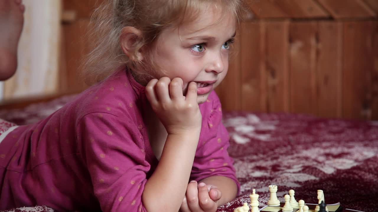 小女孩在床上下棋时消极地摇着头视频下载