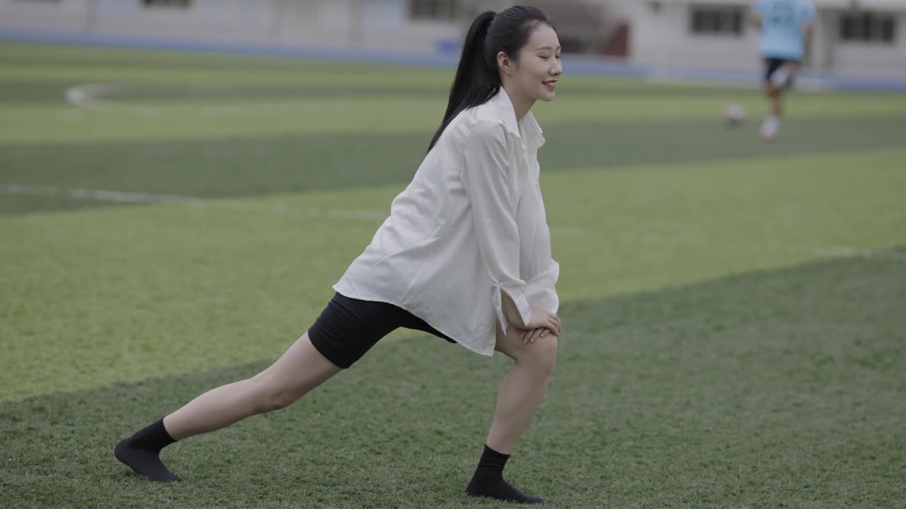 漂亮的亚洲年轻女子在操场上锻炼视频下载
