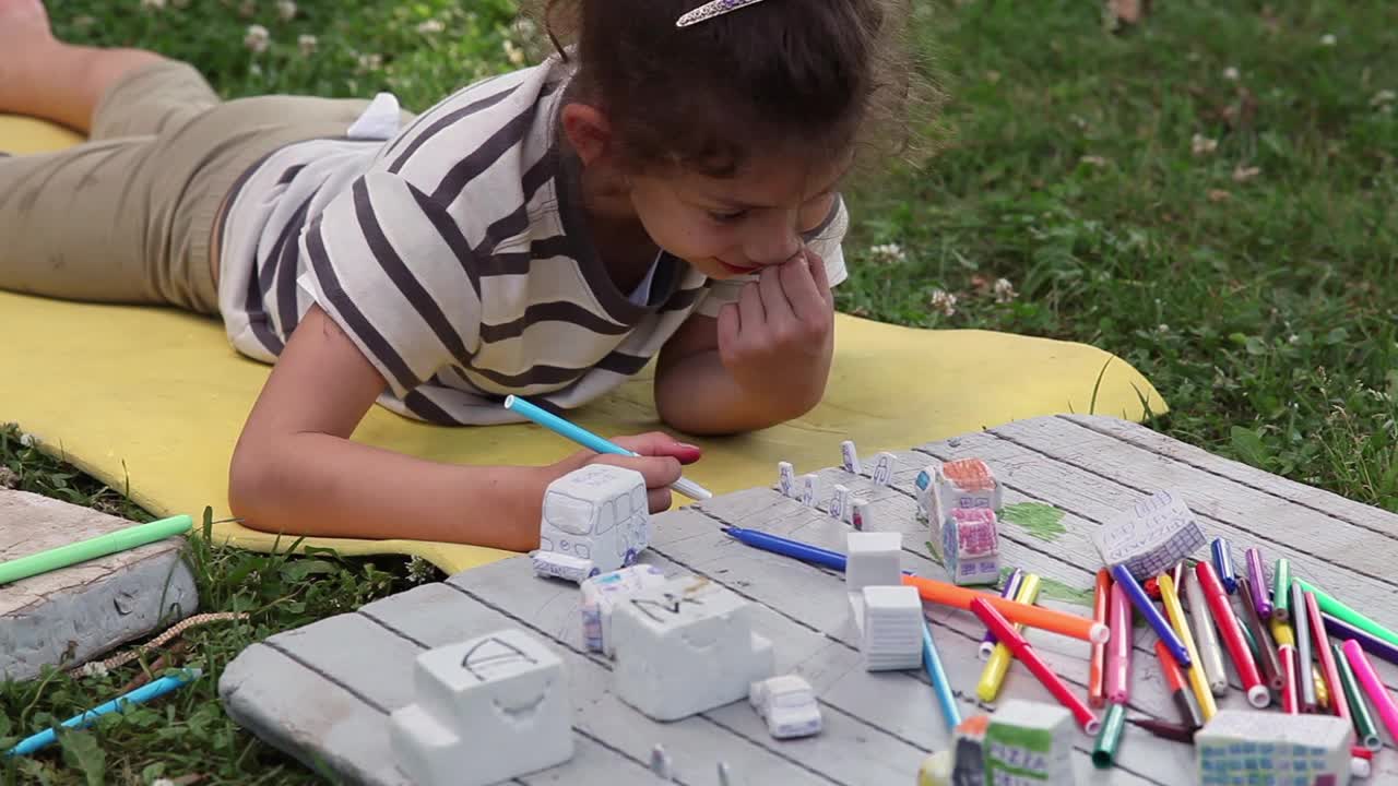 一个小女孩在后院玩玩具城的特写镜头视频下载