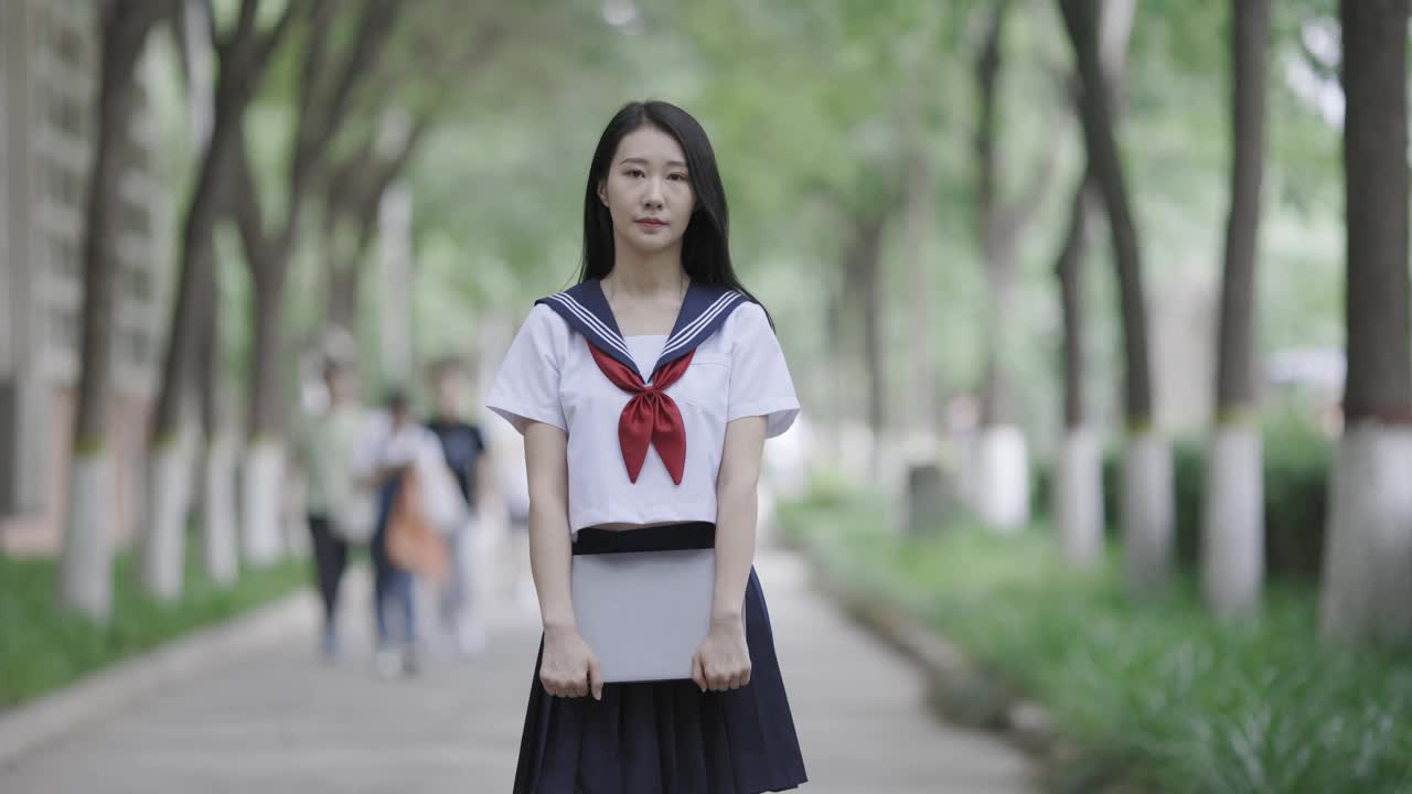 年轻的亚洲女人拿着笔记本电脑视频下载