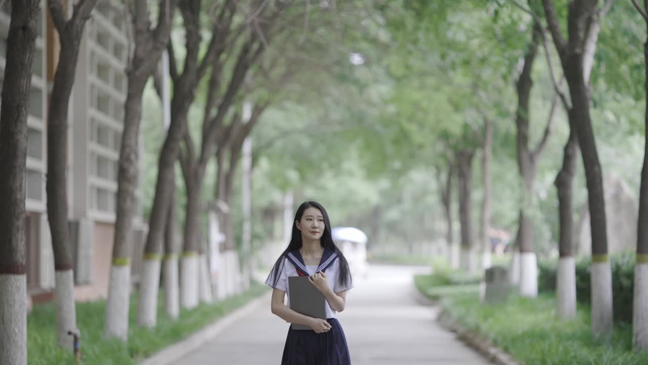 年轻的亚洲女人拿着笔记本电脑视频下载