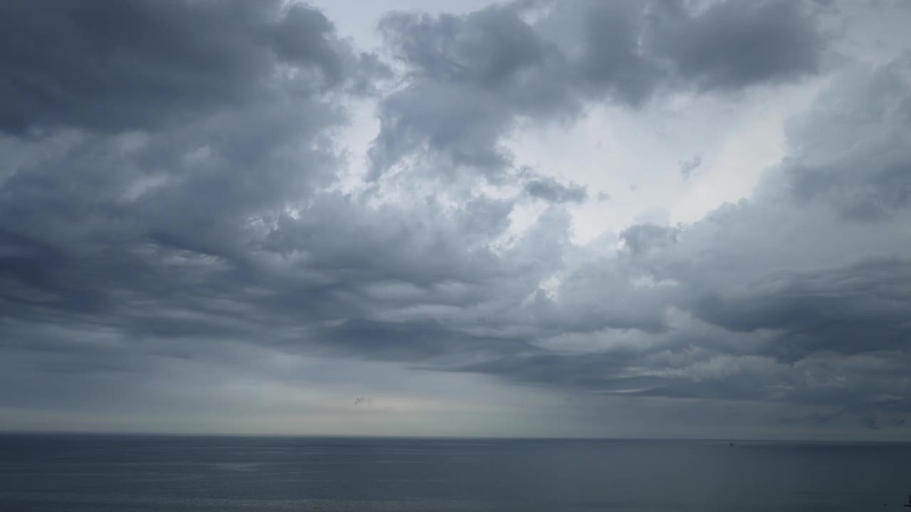 空中平移的戏剧性起伏的风暴云滚动越过天空在密歇根湖的水的一部分与雨和雷暴在远处看到的一个大的天气锋。视频素材