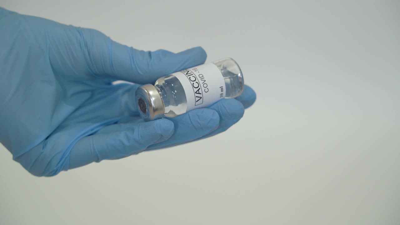 医生将冠状病毒疫苗注入注射器。视频素材