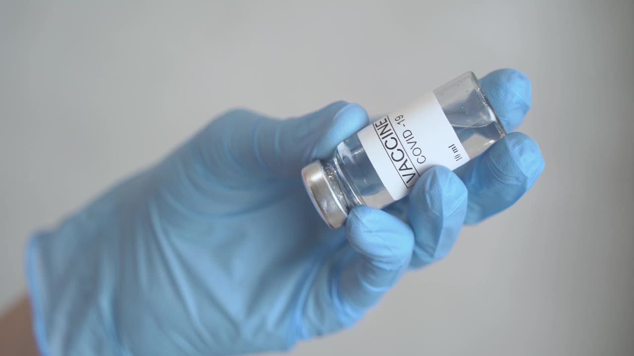 医生将冠状病毒疫苗注入注射器。视频素材