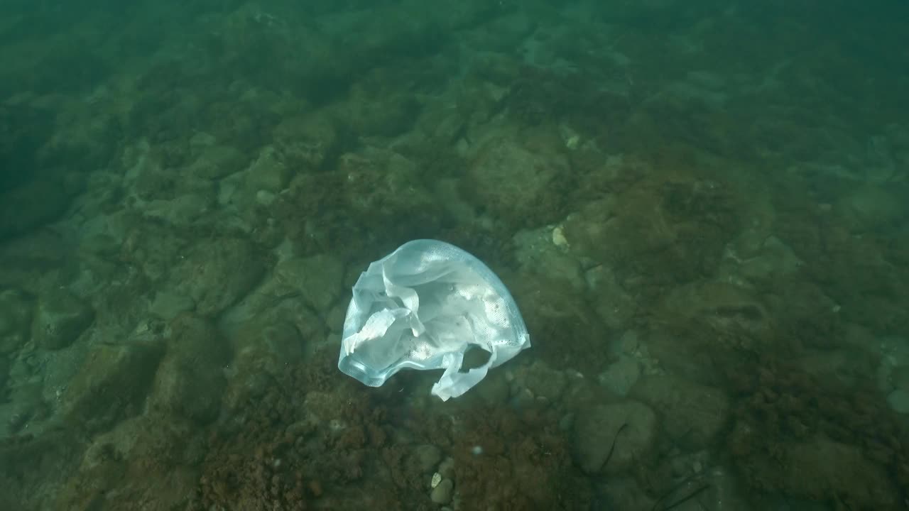 一次性塑料袋漂浮在海水中。乱扔垃圾是一场生态灾难，塑料无处不在。视频素材