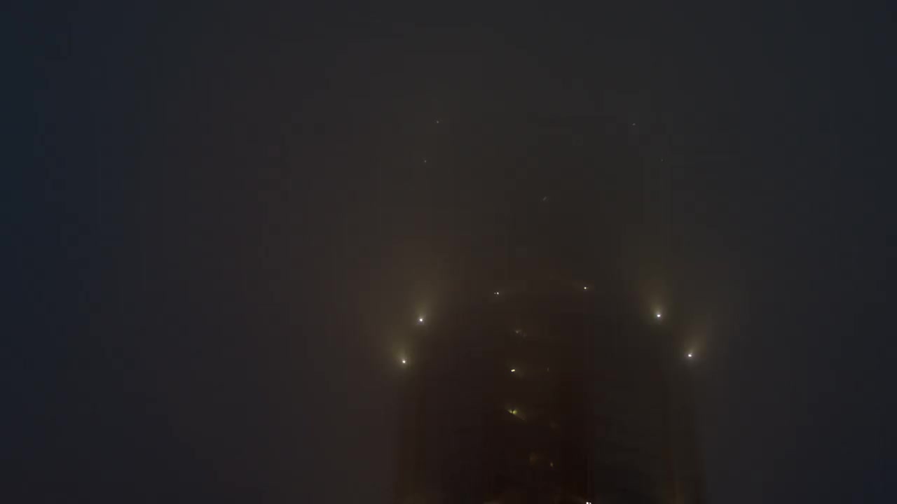 在浓雾中，一幢高层建筑上闪烁着亮光。视频素材