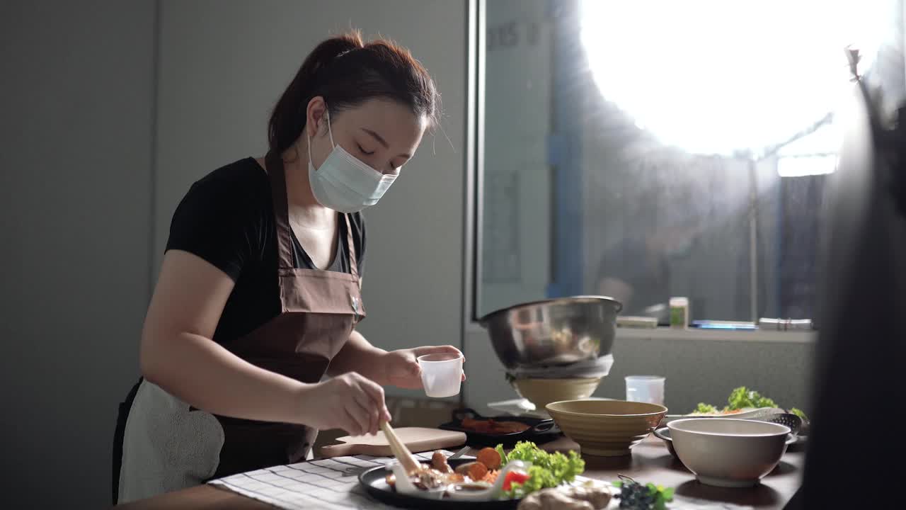 亚洲华裔女视频博主在她的家庭演播室播放装饰食品视频下载