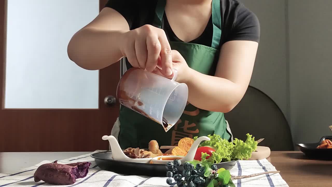 近景，亚洲华裔女视频博主在她的家庭演播室播放装饰食品视频下载