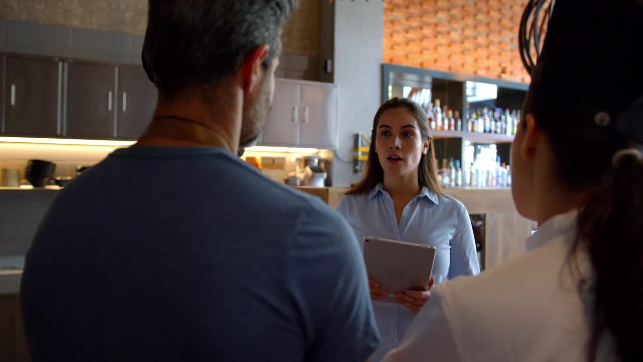 开朗的女餐厅经理在开业前的会议上指导她的团队视频素材