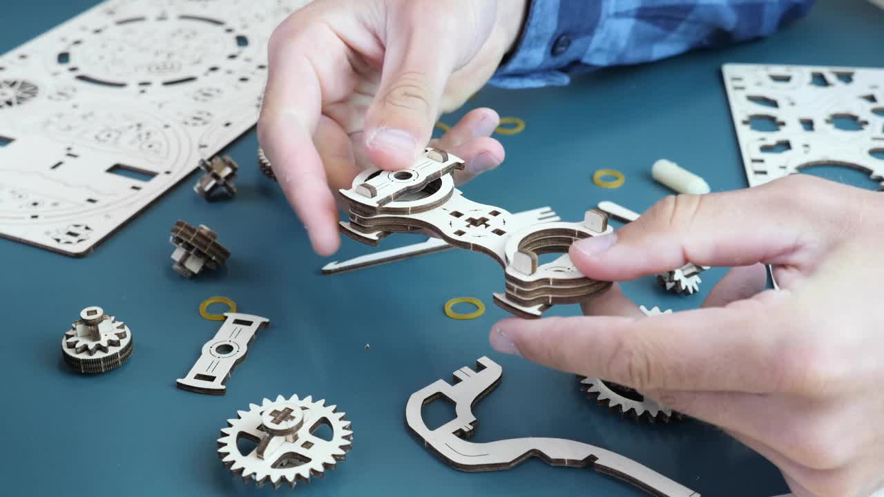 机械木制齿轮玩具。男子持有玩具细节与小机制。游戏活动视频下载