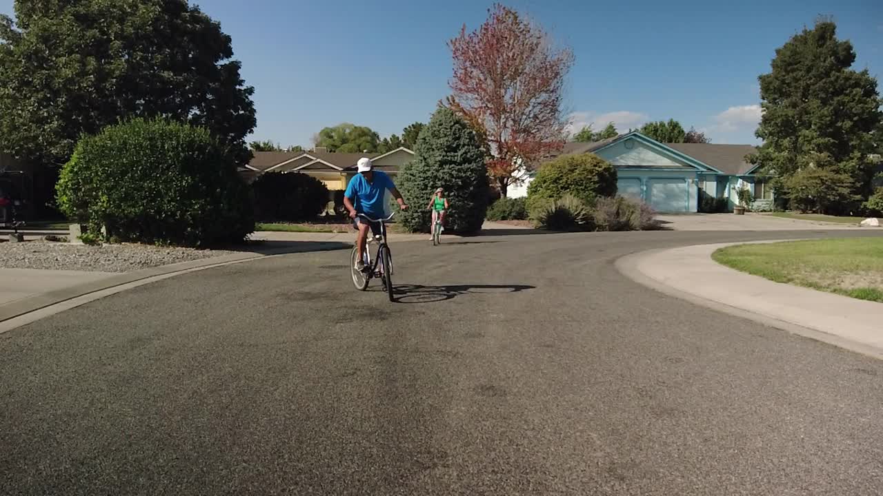 成熟的成年男性和女性异性恋夫妇骑自行车在郊区街道在美国西部4K视频系列视频素材