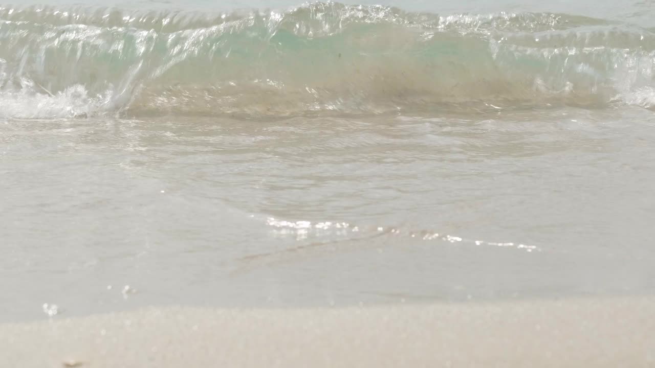 清澈的海浪在沙滩上翻滚。暑假，放松和旅行视频素材