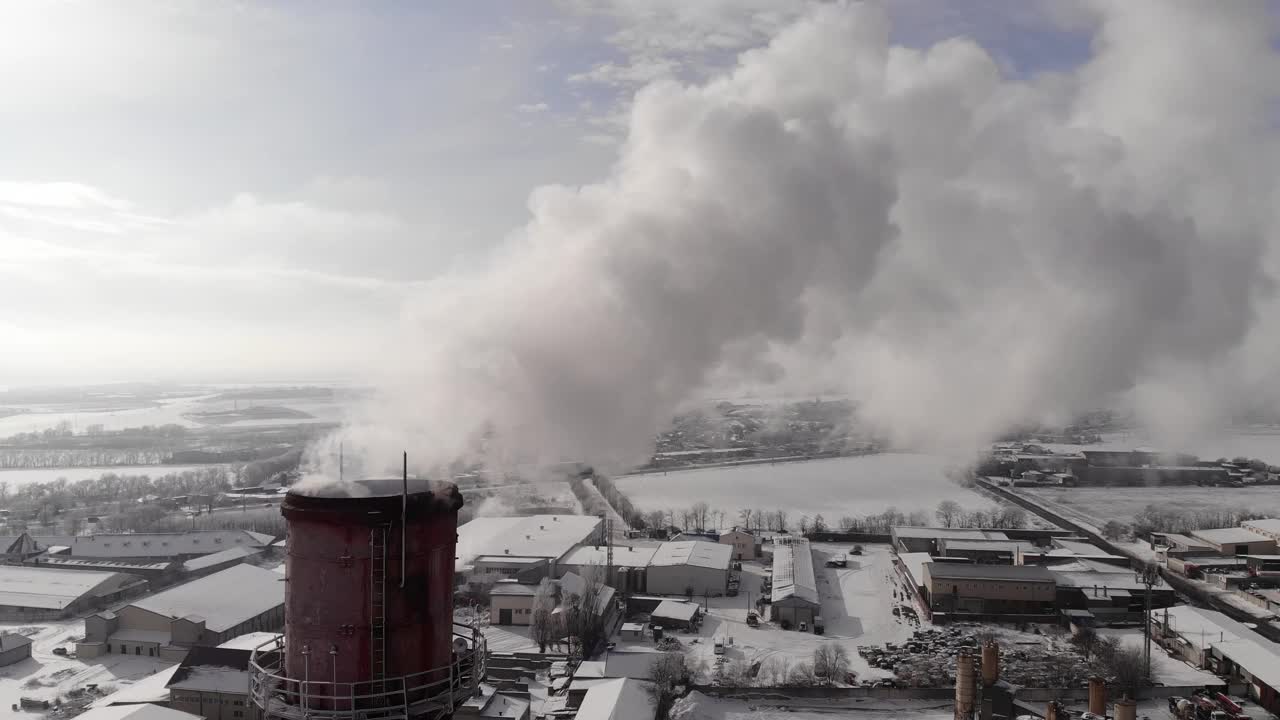 一根喷出白色烟雾的烟斗。城市燃气锅炉房的管道在冬日的天空下冒出白色的烟雾。空中特写镜头视频素材