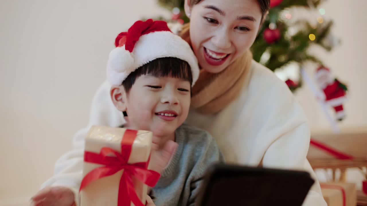 母亲和儿子在视频通话中与家人庆祝圣诞节视频下载
