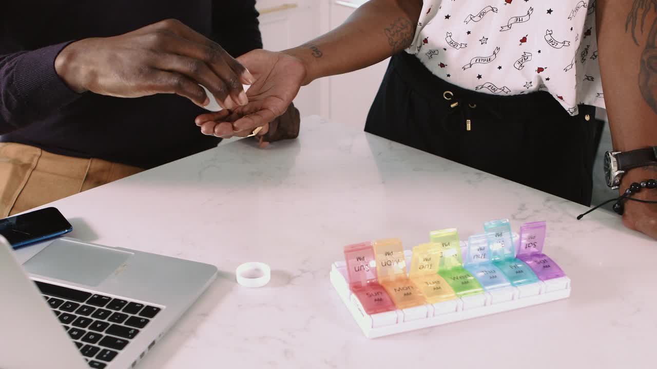 黑人夫妇组织处方药物和营养补充剂在每日药丸盒组织者视频下载