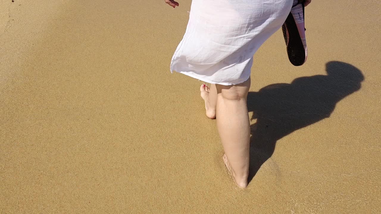 女人们在希腊的沙滩上散步视频素材