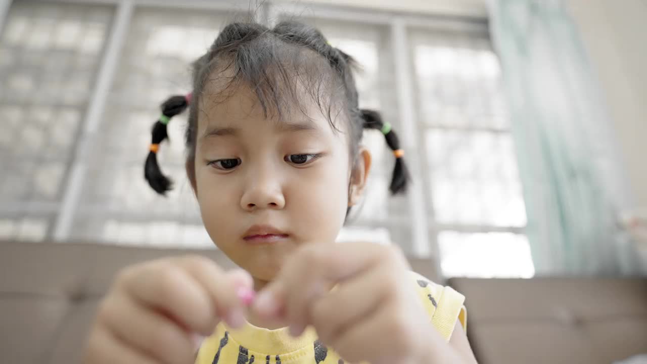 一个女孩正在练习串项链珠子。视频下载