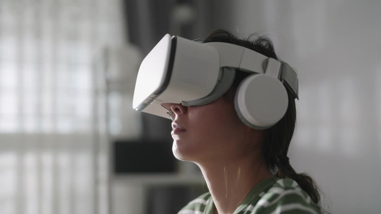 亚洲女性在家里使用虚拟现实眼镜视频素材