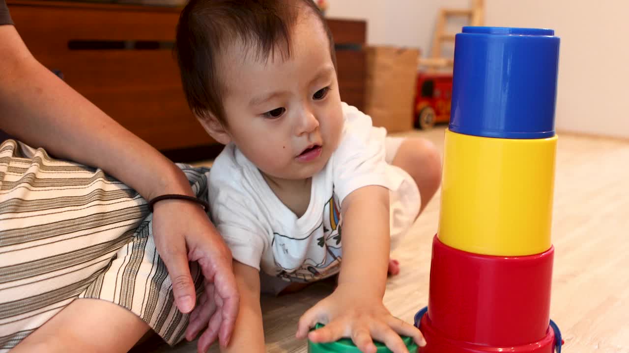 一个小男孩试图把玩具堆起来视频下载