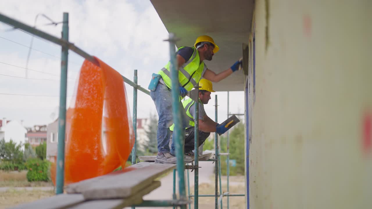 建筑工人在建筑外立面涂石膏视频素材