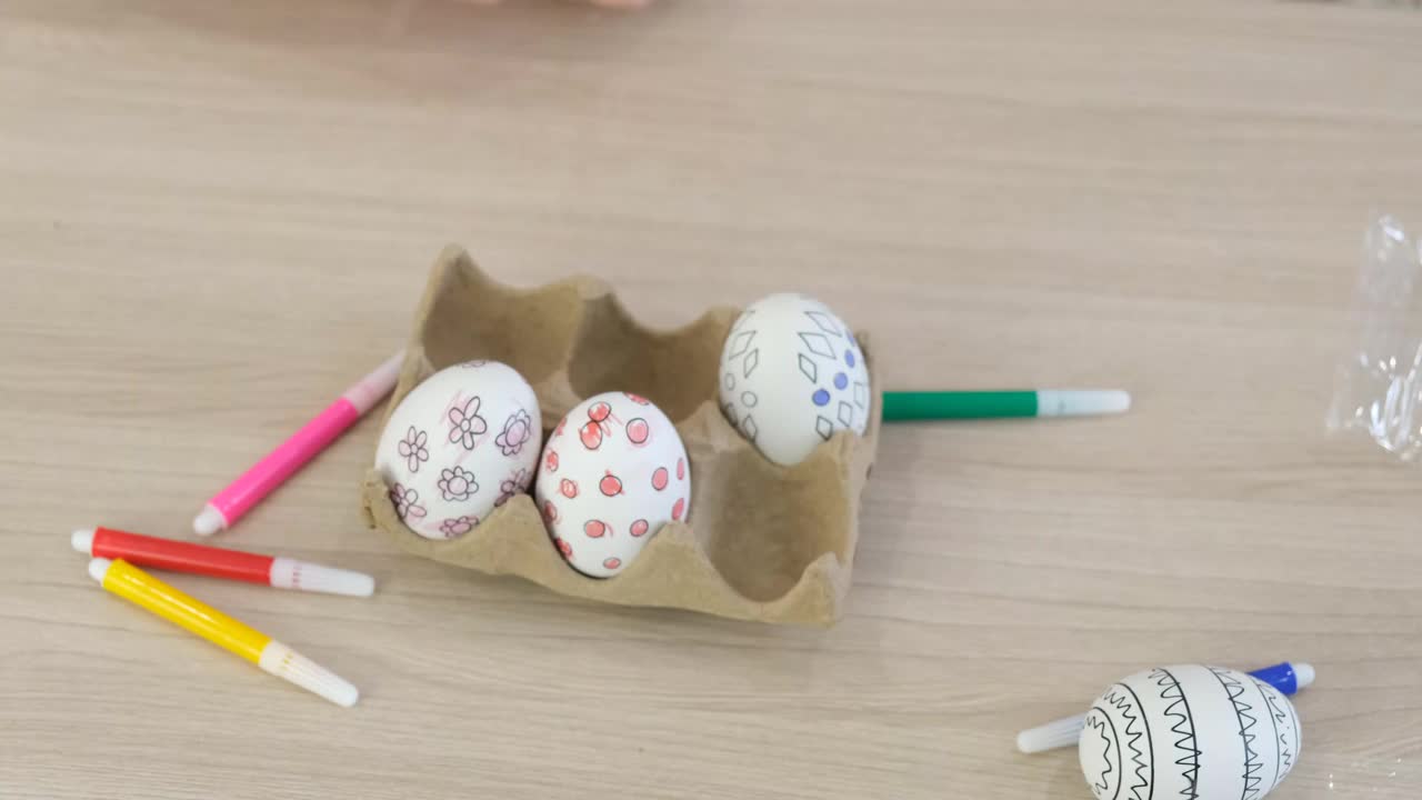 小女孩用毡头笔画复活节的装饰性纸板彩蛋视频下载