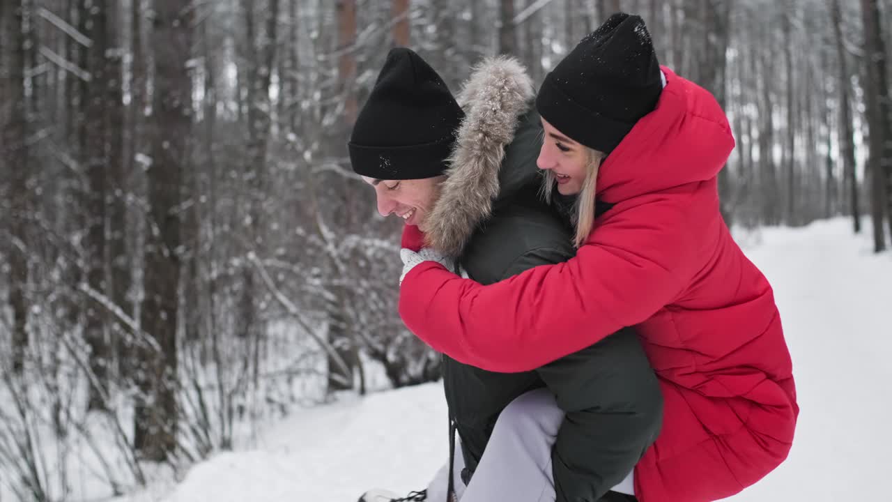 恋爱中的微笑男女在冬天的户外玩耍。年轻的夫妇视频下载