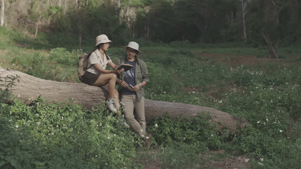 年轻的成年夫妇在泰国的森林里读书视频下载