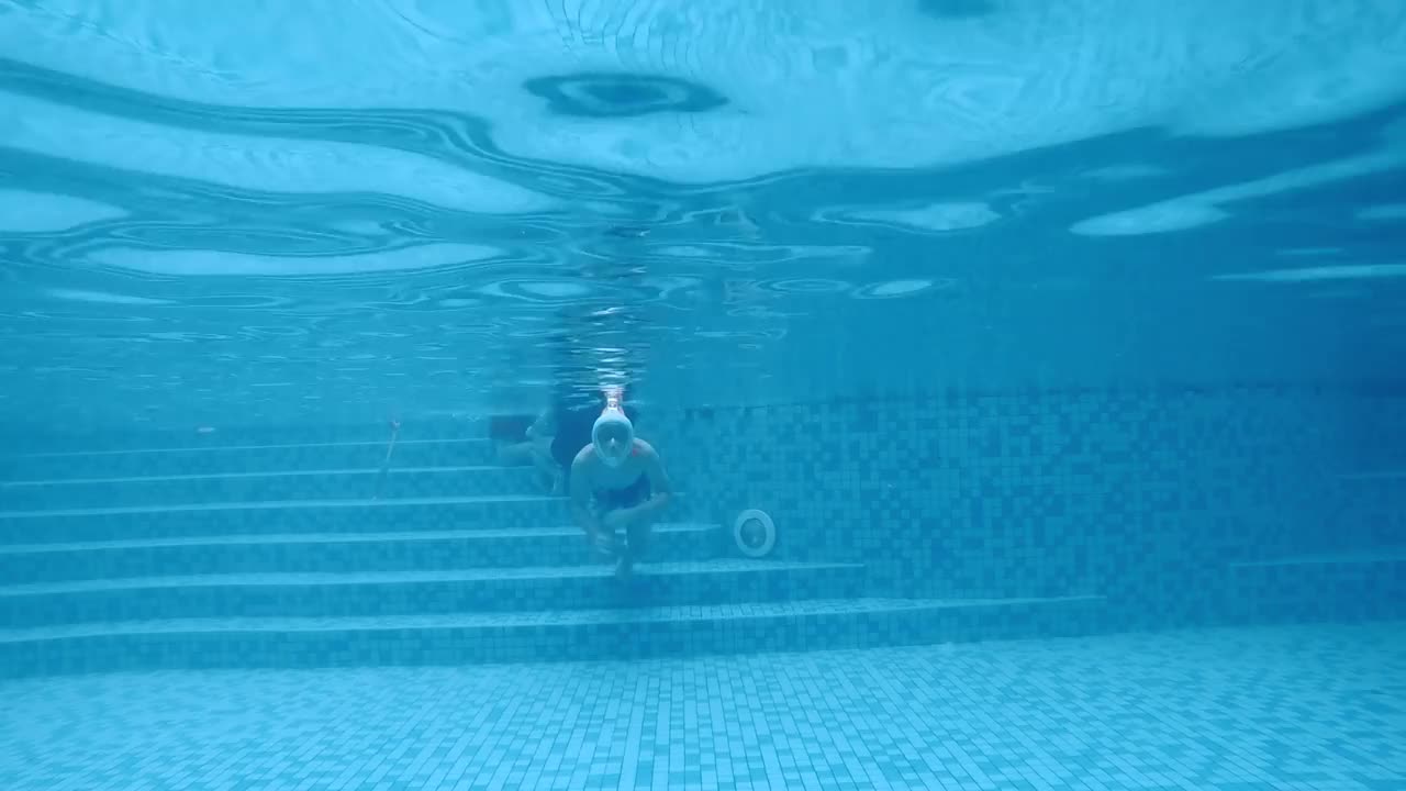 低角度的观点亚洲中国少年男孩游泳通过游泳池使用浮潜面罩和管道在假期。视频素材