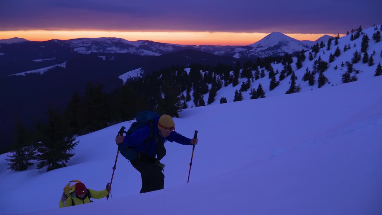 登山朋友登高雪上，走向高山之巅视频素材