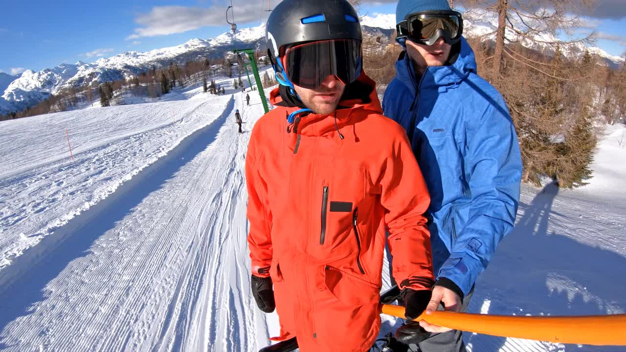 在阳光明媚的日子里，朋友们在滑雪板上乘坐滑雪缆车上山视频素材