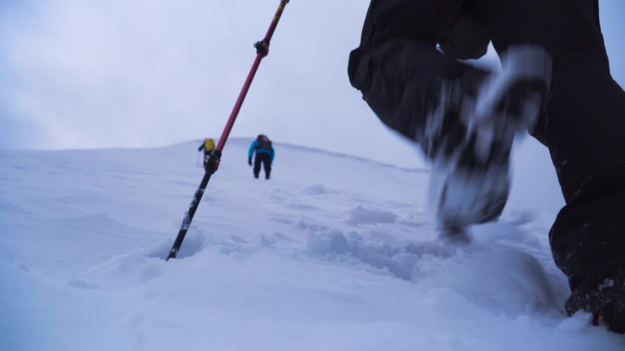 登山朋友登高雪上，走向高山之巅视频素材