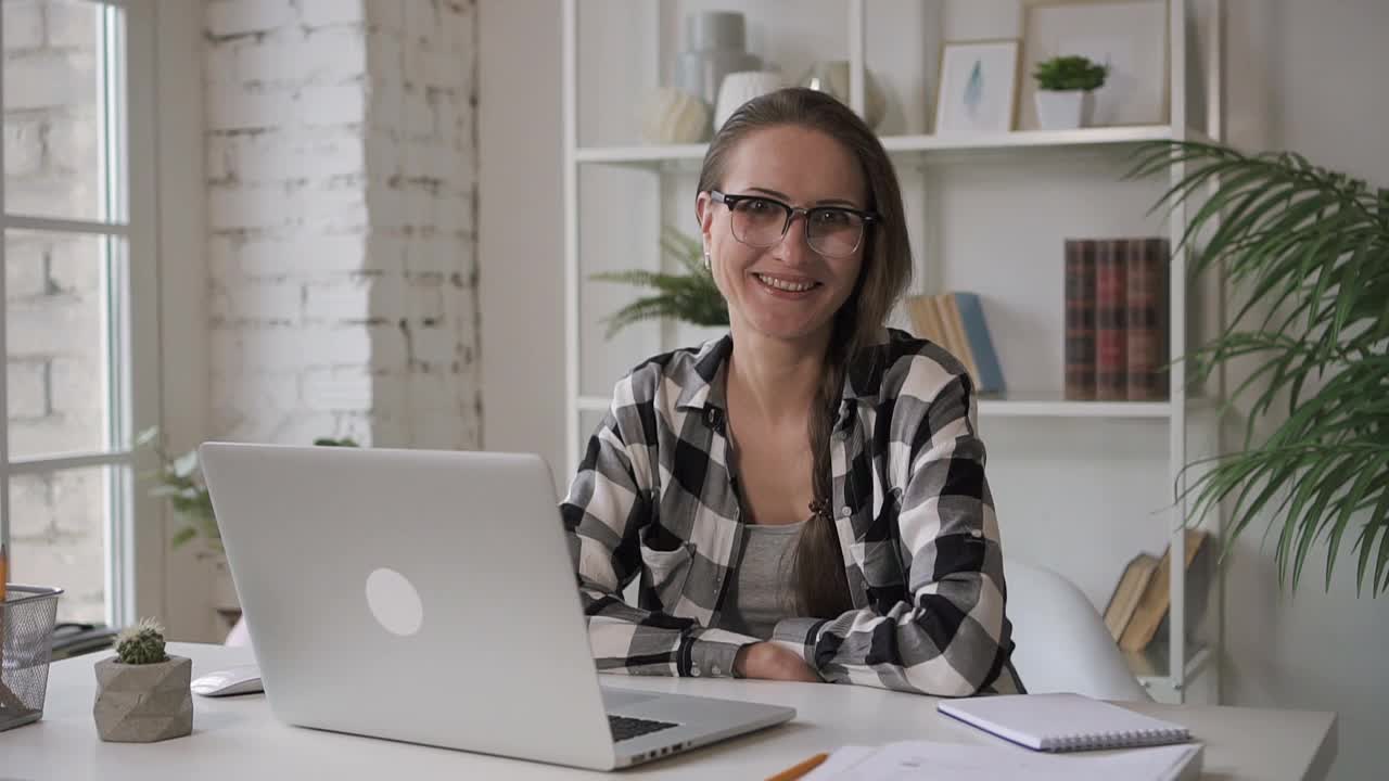 女企业主程序员微笑着在办公室，在笔记本电脑上工作视频下载