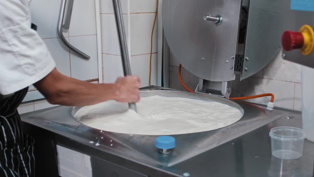 奶酪生产-一名男子混合奶酪的基础视频素材