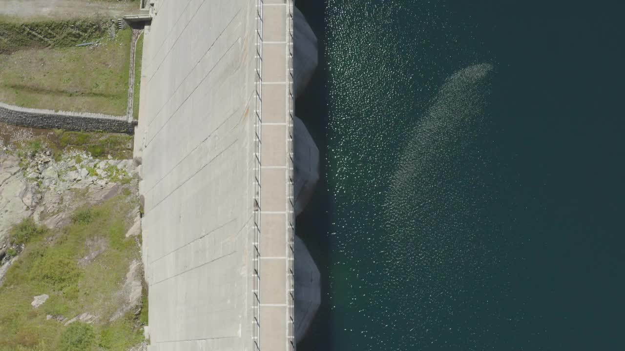 无人机在一个晴朗的日子拍摄了一座大坝，山上有深蓝色的水视频素材
