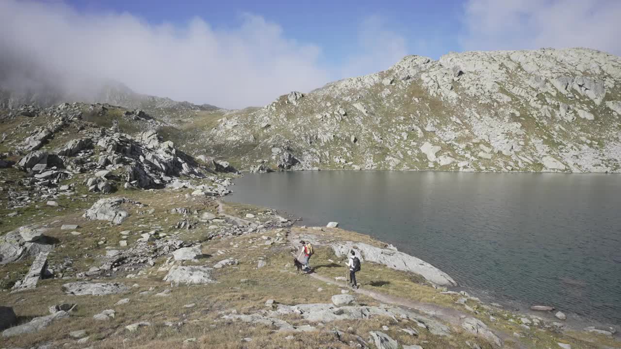 一男一女在山上的湖上徒步旅行的广角镜头视频素材