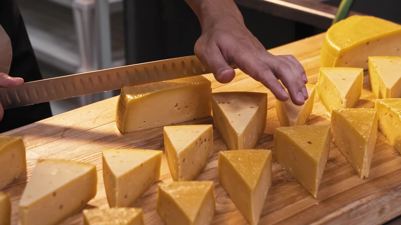 商店里的一个人用一把大刀把一块奶酪切成三角形视频素材
