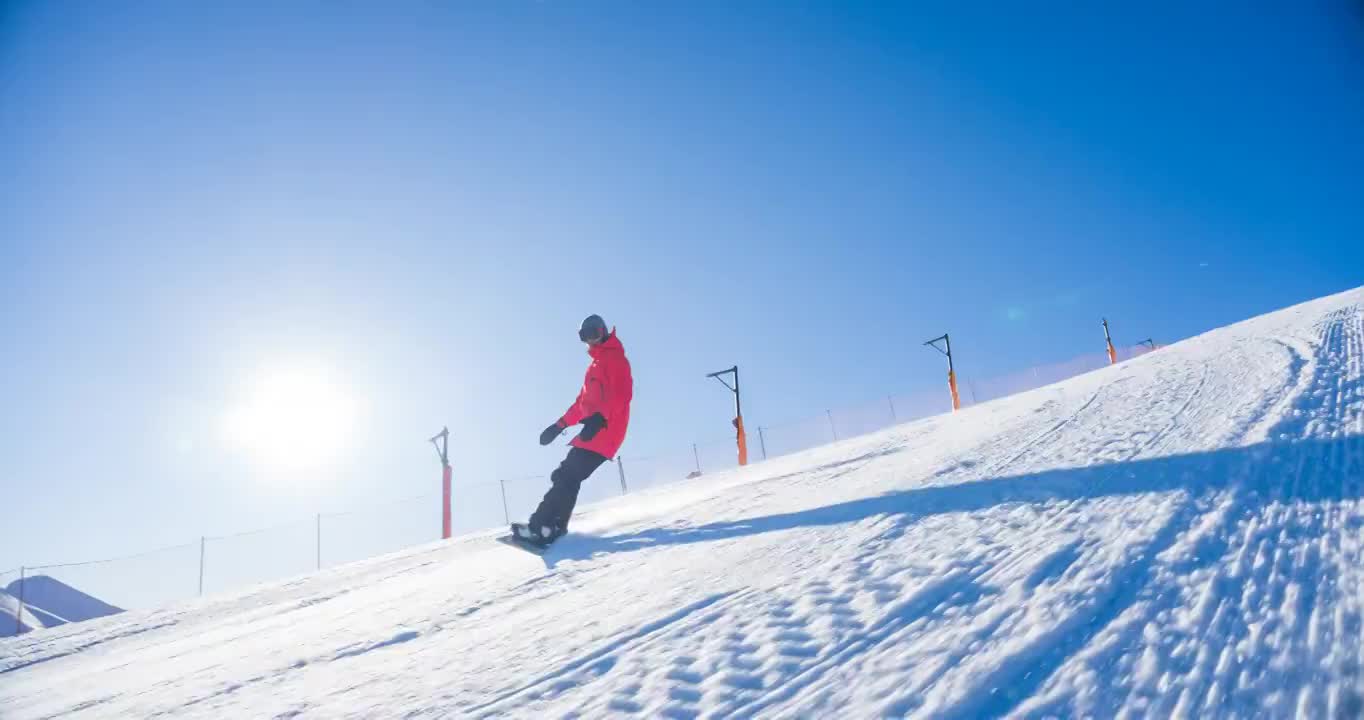 在阳光明媚的日子里，滑雪者从滑雪坡道上滑下来视频素材