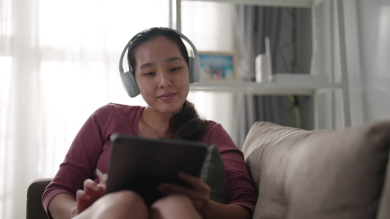 亚洲女性在家里使用数码平板电脑视频下载