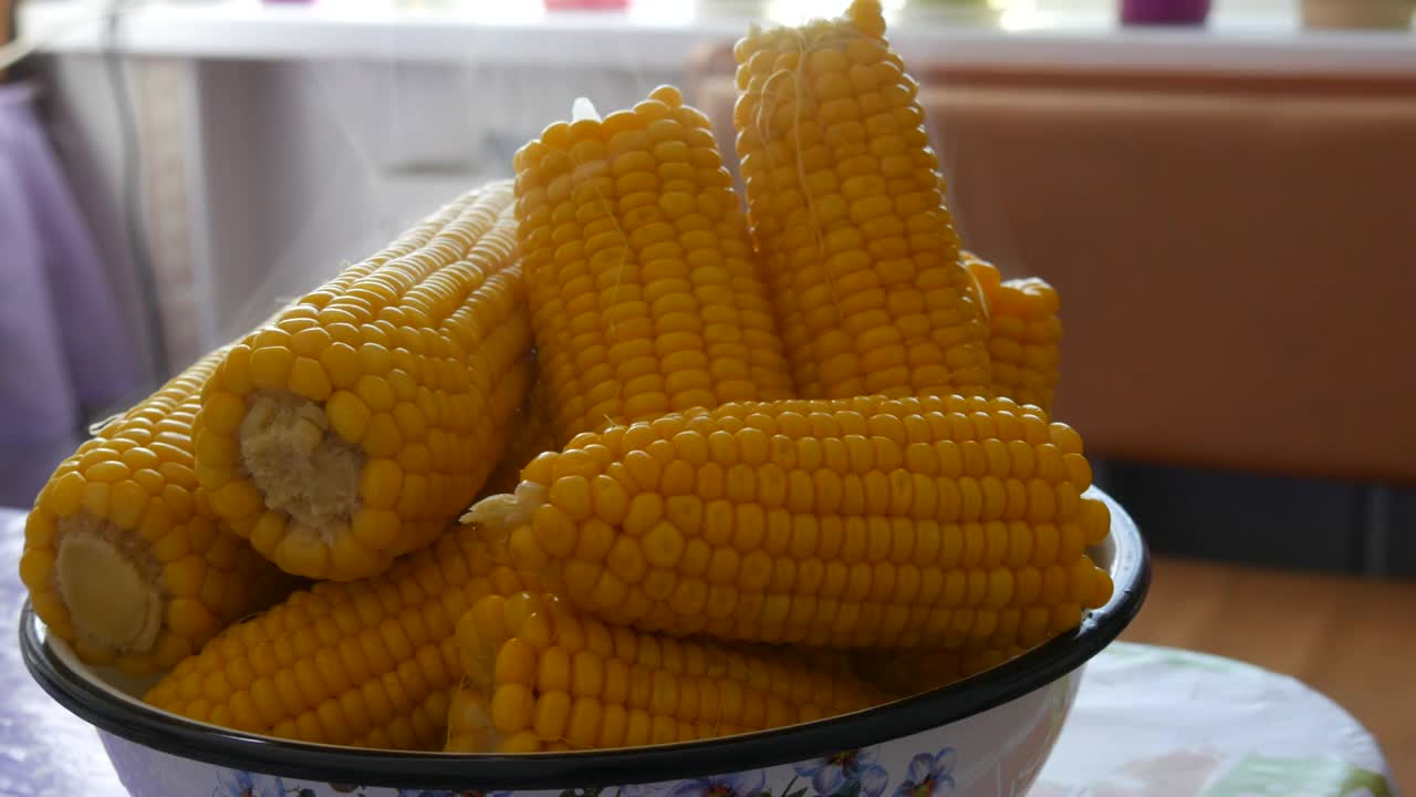在家里厨房的大碗里煮玉米。蒸汽出来视频素材