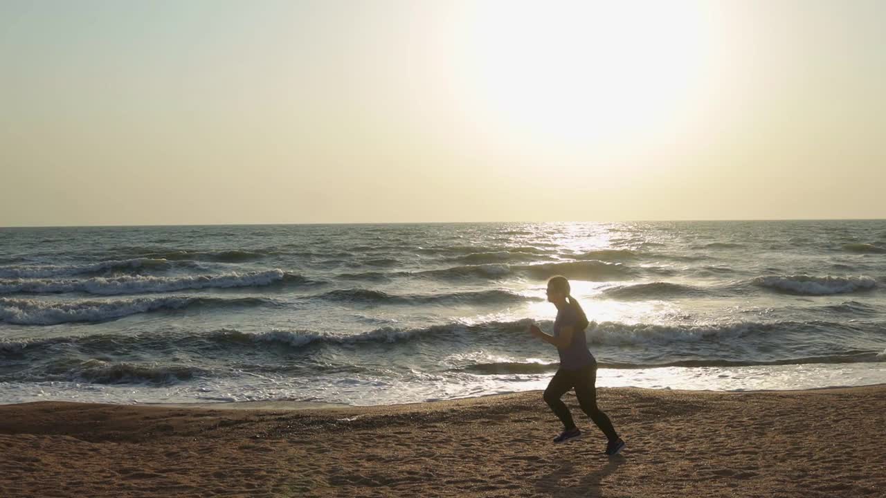 听着音乐，在海边奔跑的女人视频素材
