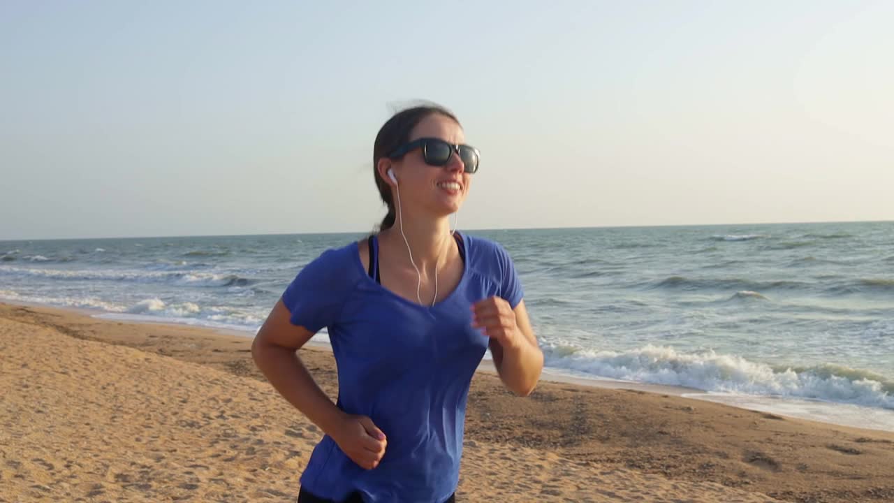 听着音乐，在海边奔跑的女人视频素材