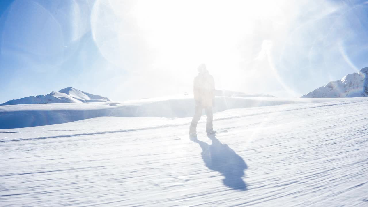 在一个完美的阳光灿烂的冬日，滑雪者在田园诗般的滑雪胜地滑雪道上滑行视频素材