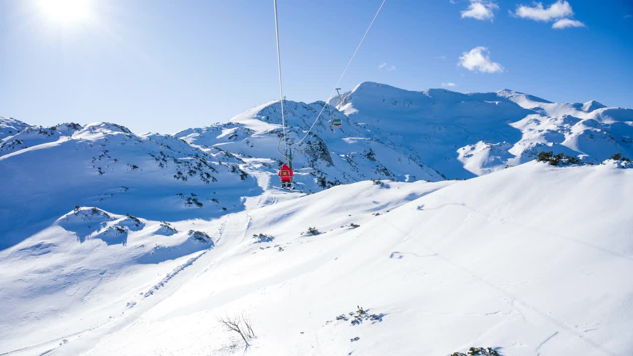 在阳光明媚的日子里，在滑雪胜地乘坐缆车欣赏山景视频素材