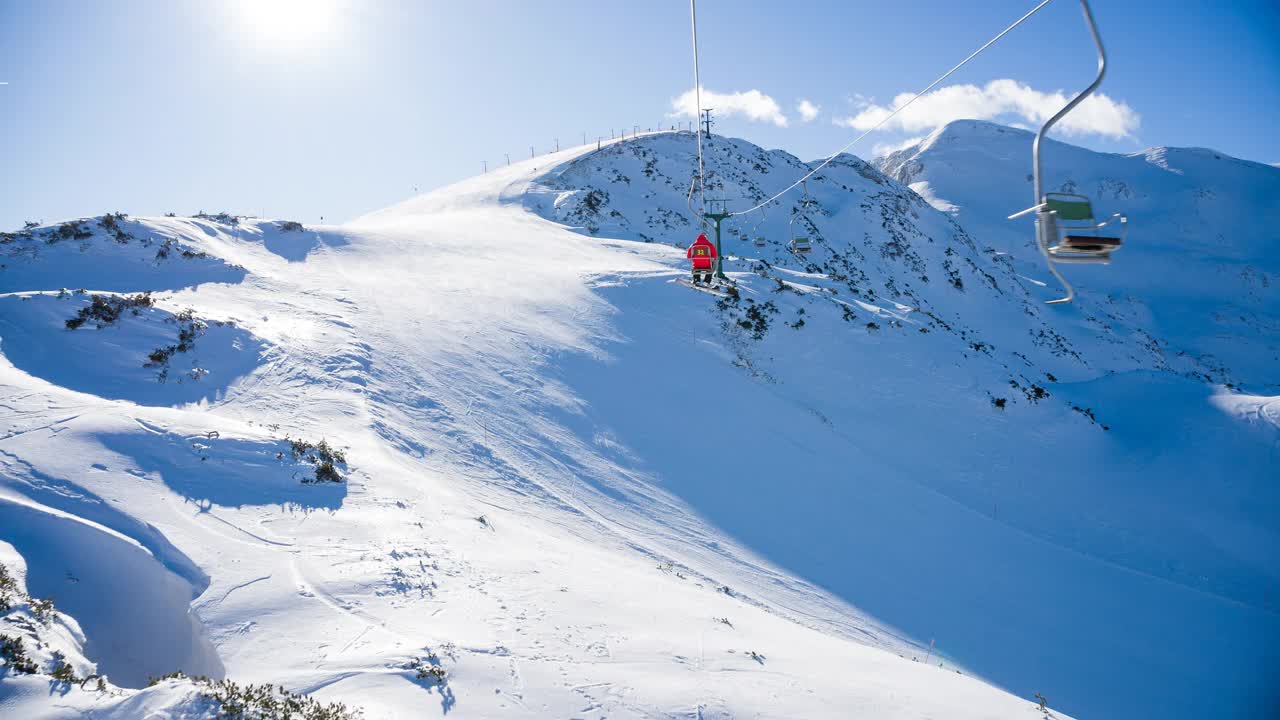 在滑雪胜地乘坐单人缆车到达雪山山顶视频素材