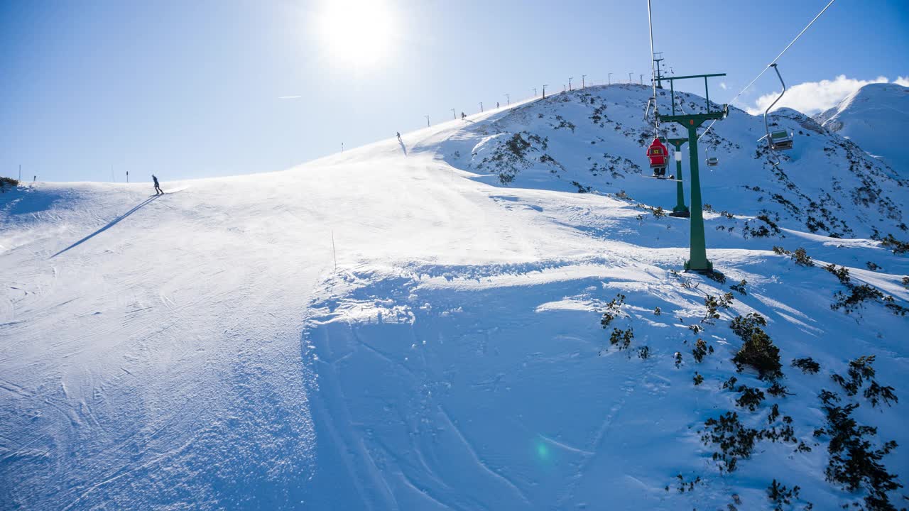 在滑雪胜地乘坐单人缆车到达雪山山顶视频素材