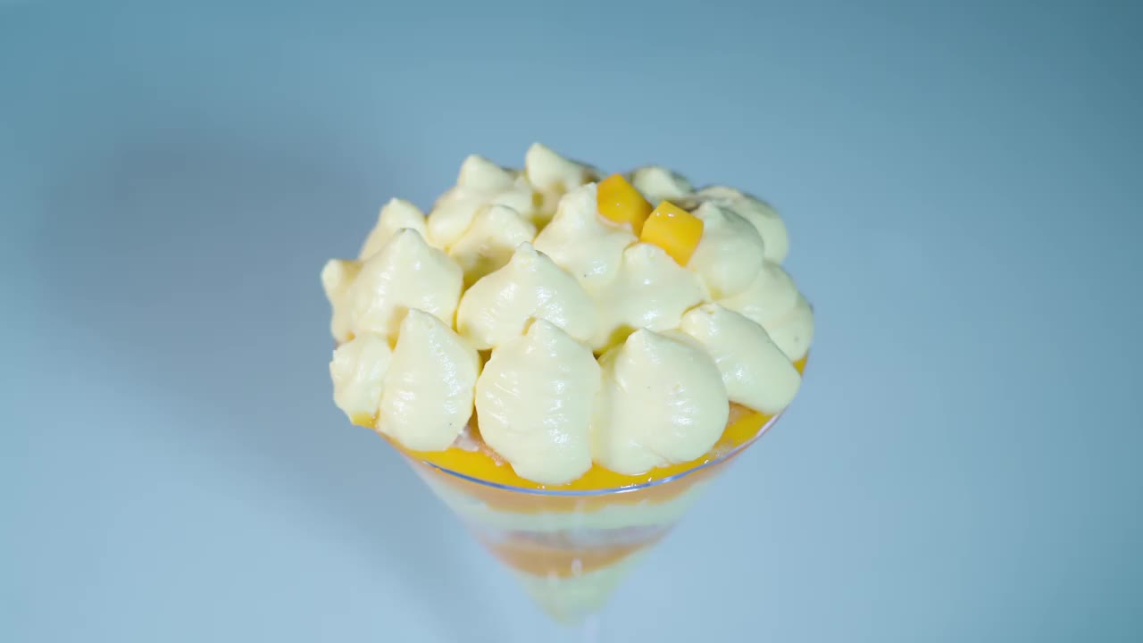 切好的芒果放在玻璃杯里的奶油上面视频素材