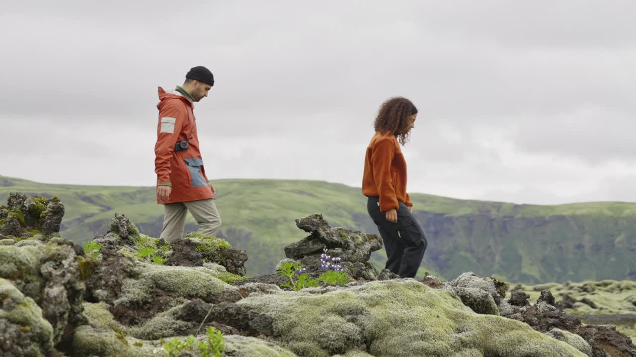 年轻夫妇在苔藓和岩石上徒步旅行视频素材