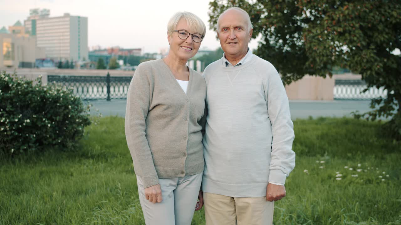 老夫妇站在现代城市街道的户外微笑的肖像视频下载