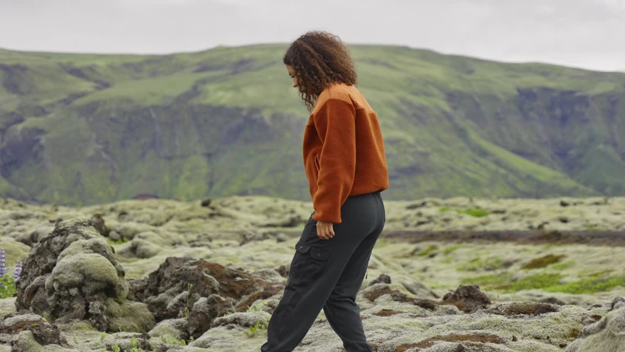 女人徒步在苔藓覆盖的岩石景观视频下载
