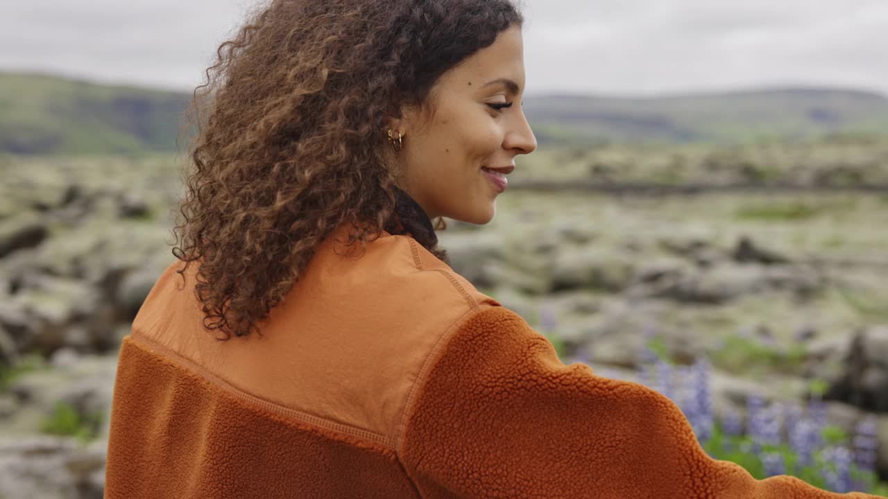 微笑的年轻女子拿着相机在冰岛风景视频下载